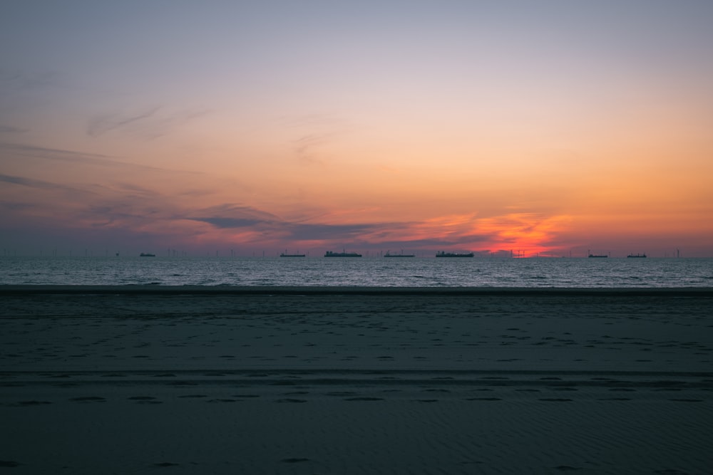 太陽は遠くに船で海に沈んでいます