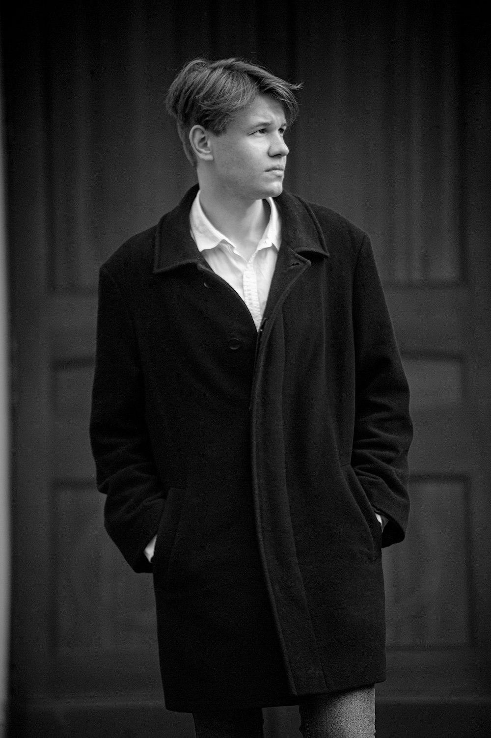 a black and white photo of a man in a coat