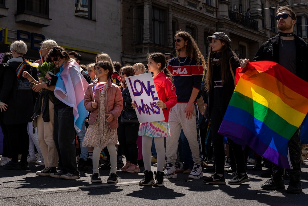 eine gruppe von menschen, die eine regenbogenflagge halten