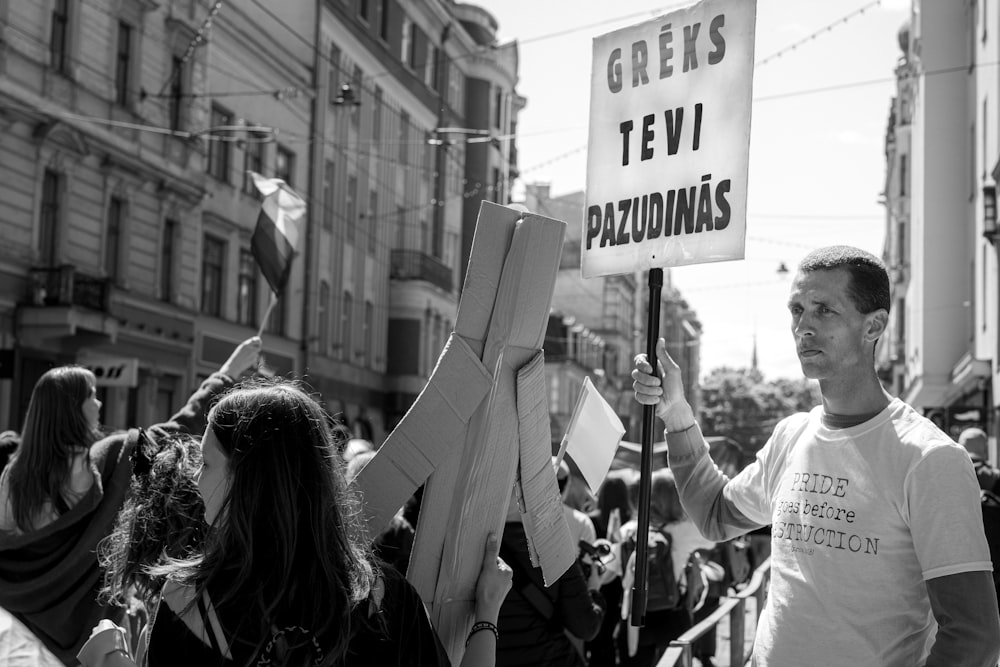 a man holding a sign in the middle of a crowd