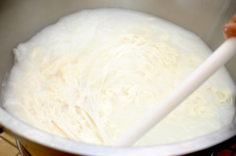 a large pot filled with white batter and a wooden spoon