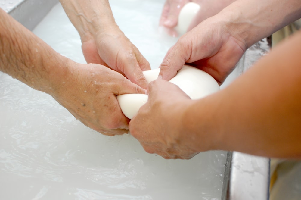 a couple of people that are kneading some food