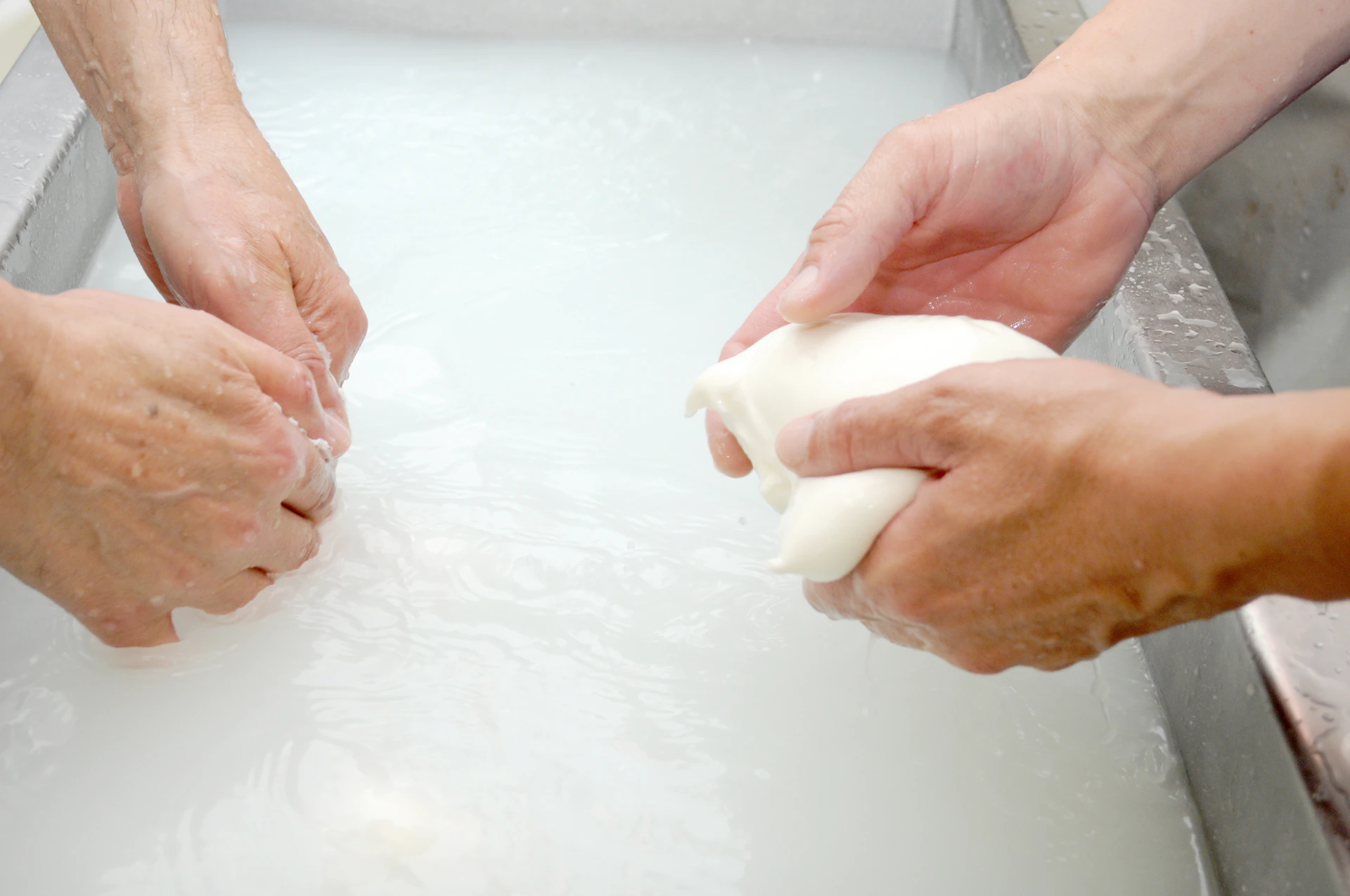 a couple of people washing their hands in a sink