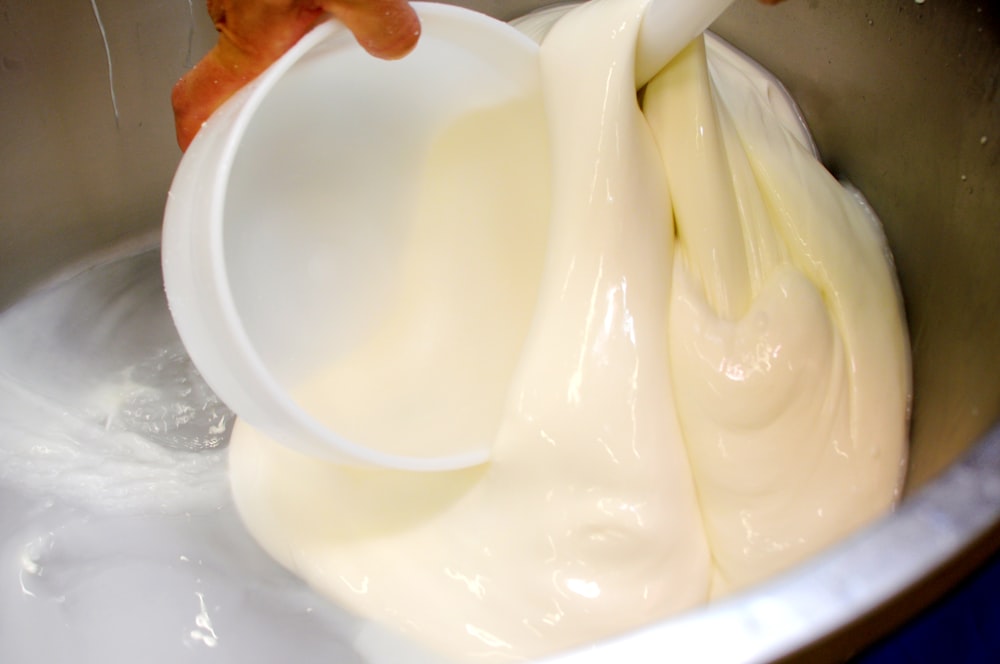 a mixing bowl filled with a mixture of cream