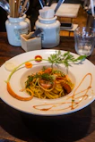 A happy young couple enjoying a beautifully plated pasta meal in a bright, minimalist dining space