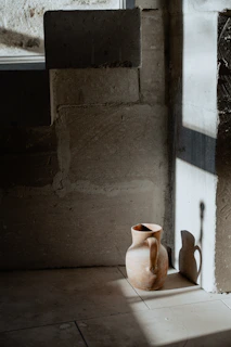 Soft natural light illuminating a quirky hand-thrown pitcher with playful green tones.