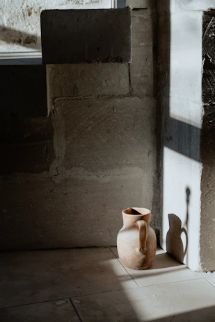 Soft natural light illuminating a quirky hand-thrown pitcher with playful green tones.