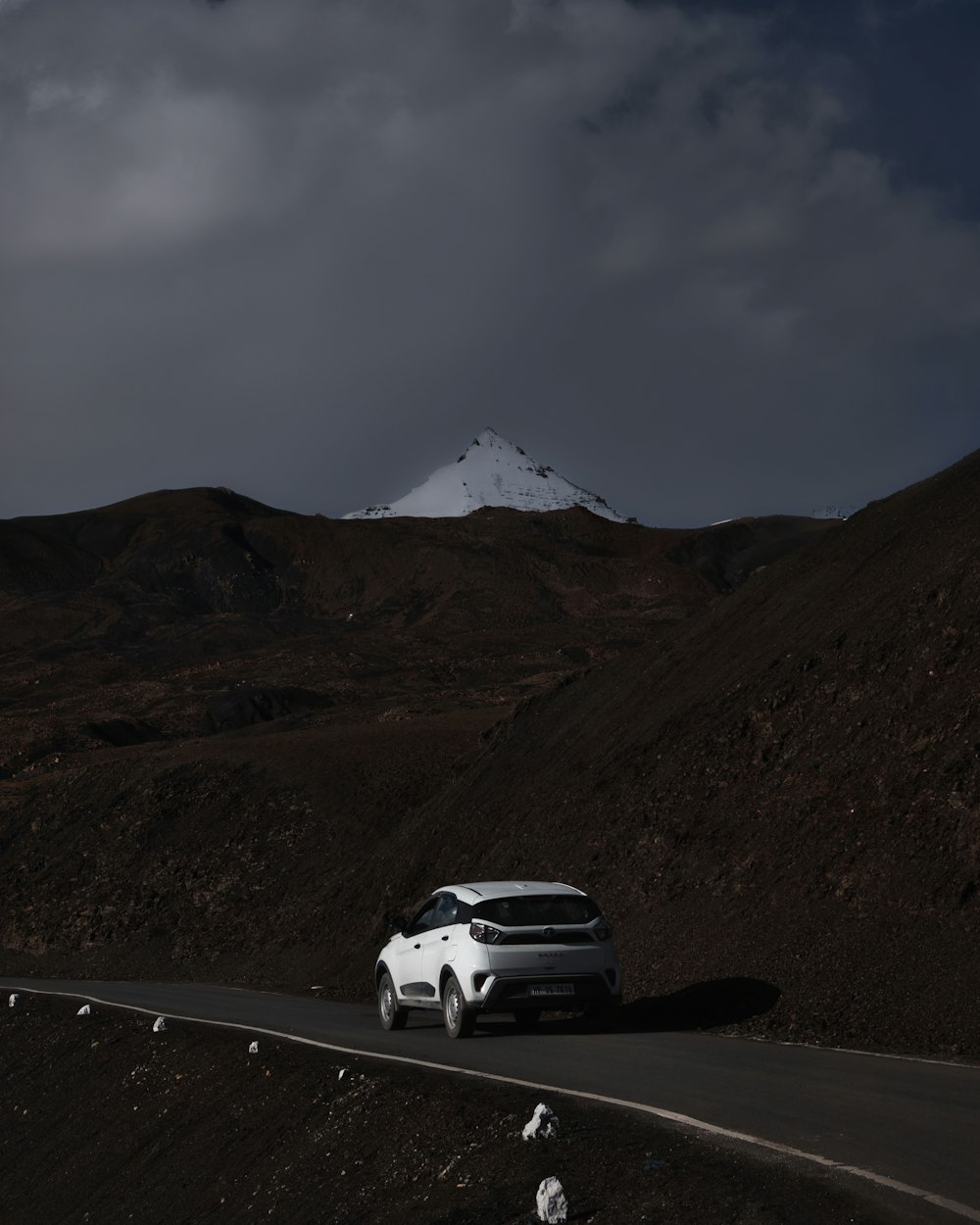 a white car driving down a mountain road