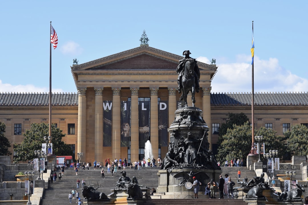 a large building with a statue in front of it, Downtown Philadelphia.