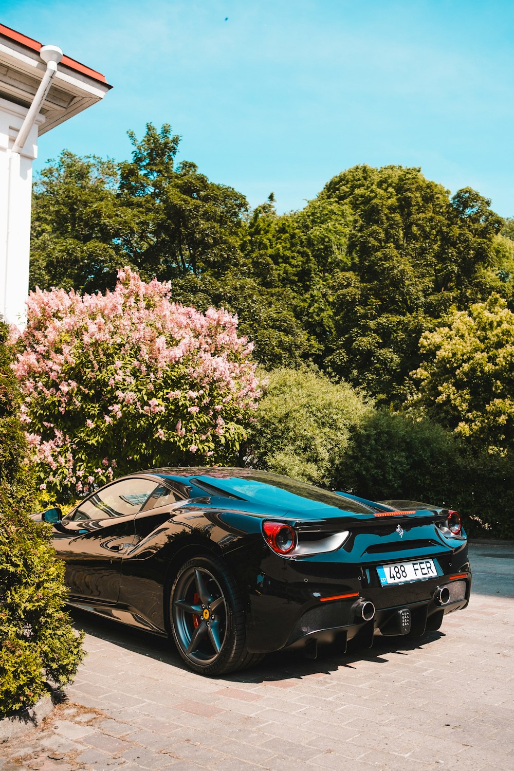 a black sports car parked in front of a house