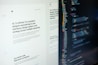 A computer screen displaying web design content and code side by side. The left side features text describing a product designer's work and experience, while the right side shows colorful, highlighted code lines on a dark background.