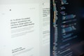 A computer screen displaying web design content and code side by side. The left side features text describing a product designer's work and experience, while the right side shows colorful, highlighted code lines on a dark background.