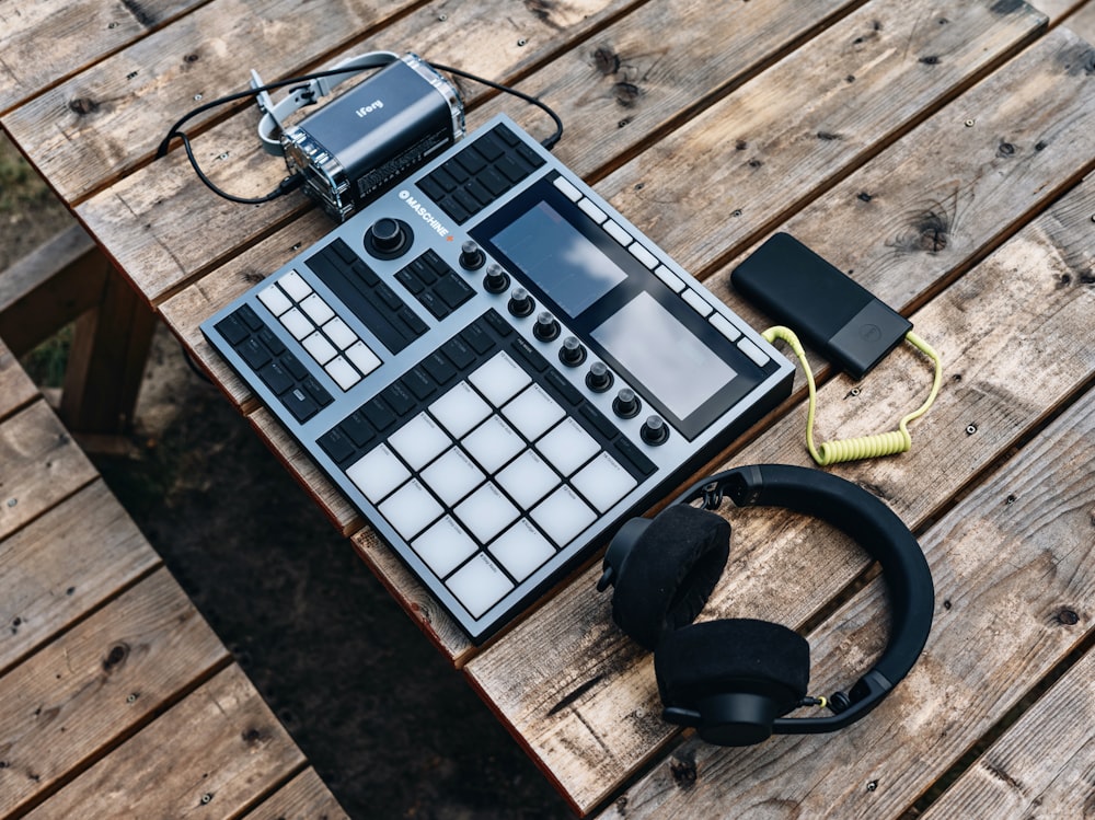 a table with headphones, headphones, and an electronic device on it