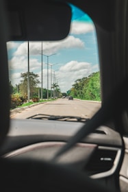 A dashboard view of a car driving on a highway with clear skies.
