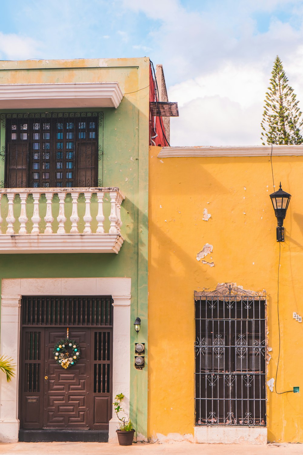 Un edificio amarillo con una puerta y ventana marrón