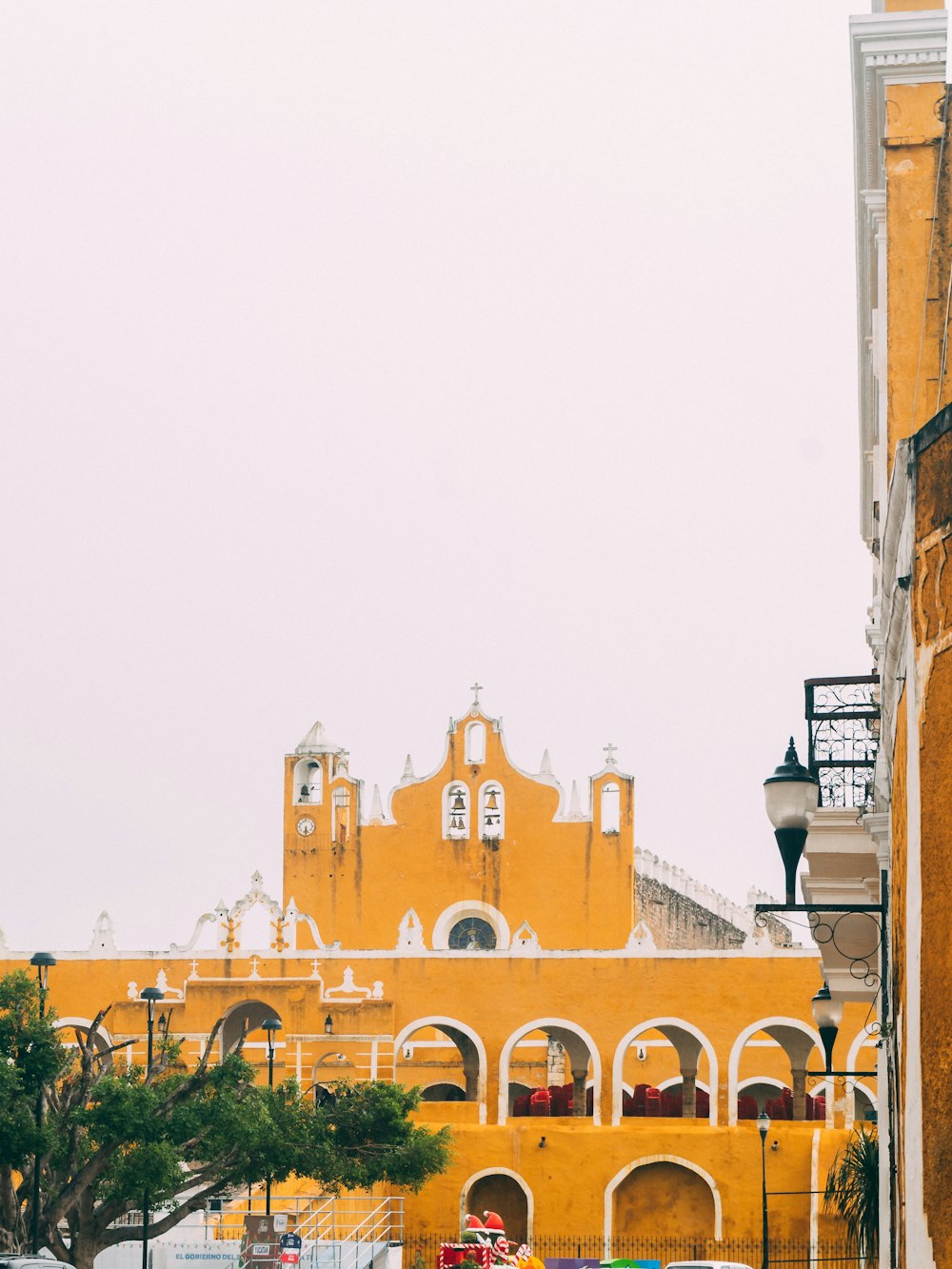 a yellow building with a clock tower in the background