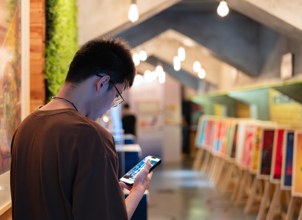 a man looking at a cell phone in a store