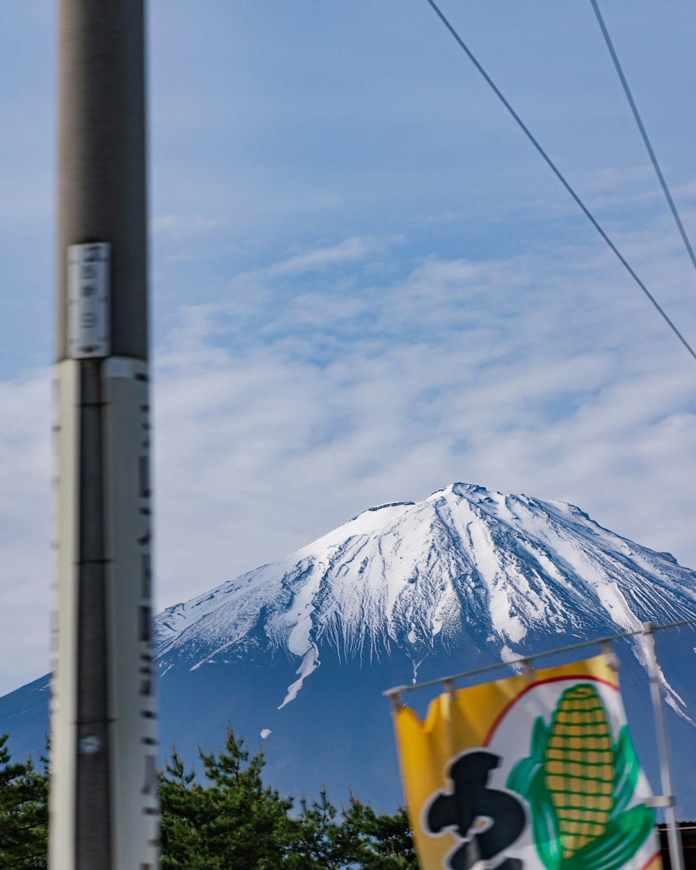 a tall pole with a flag and a mountain in the background