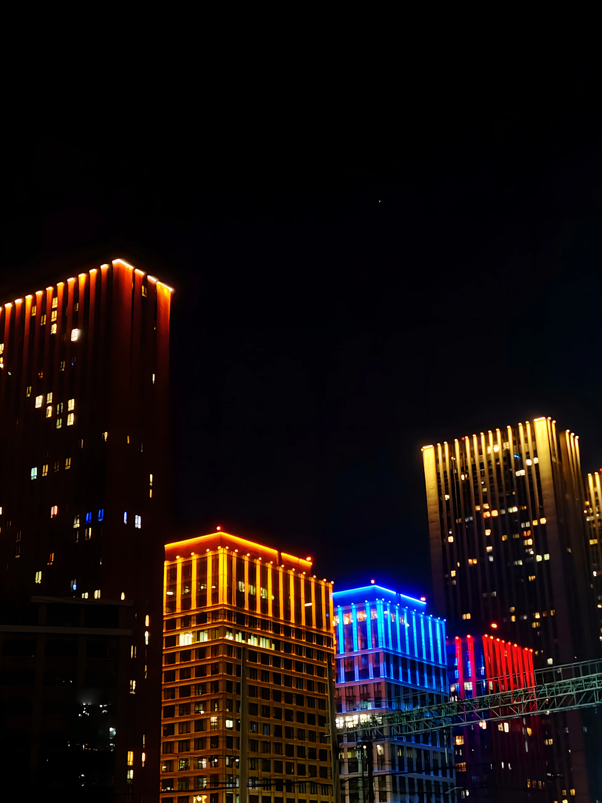 a group of tall buildings lit up at night