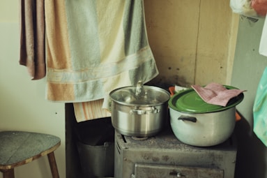 a stove top oven sitting next to a pot on top of a wooden table