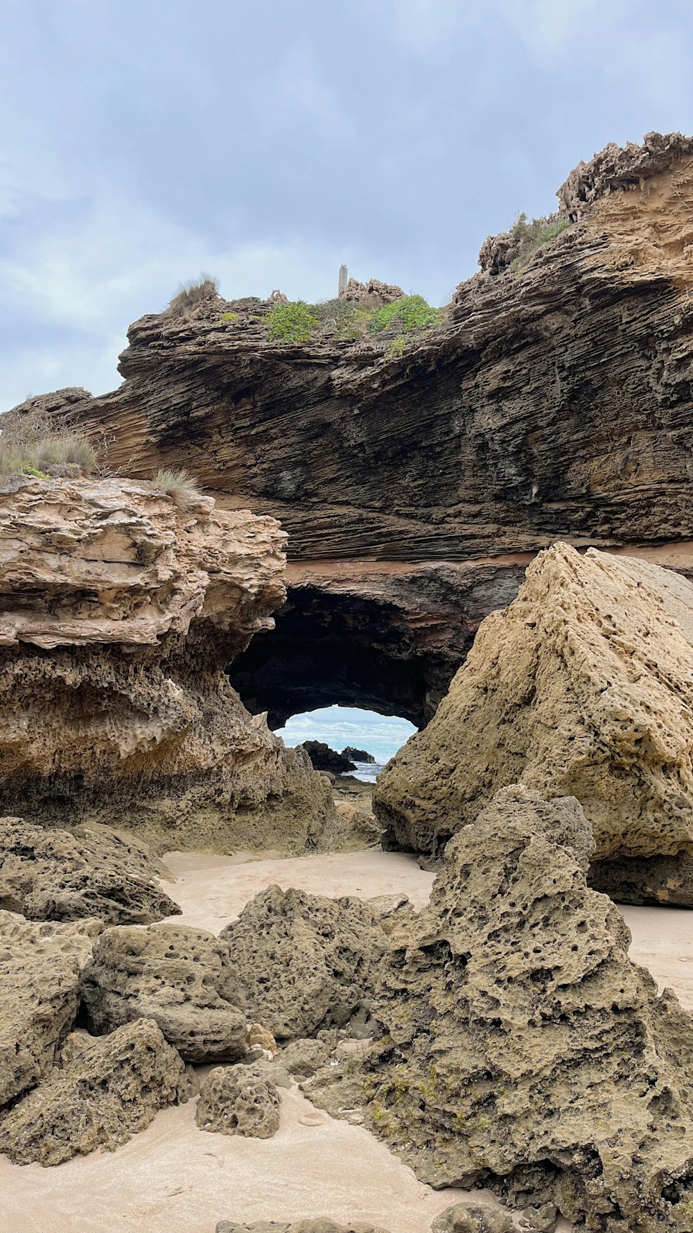 a rocky beach with a cave in the middle of it