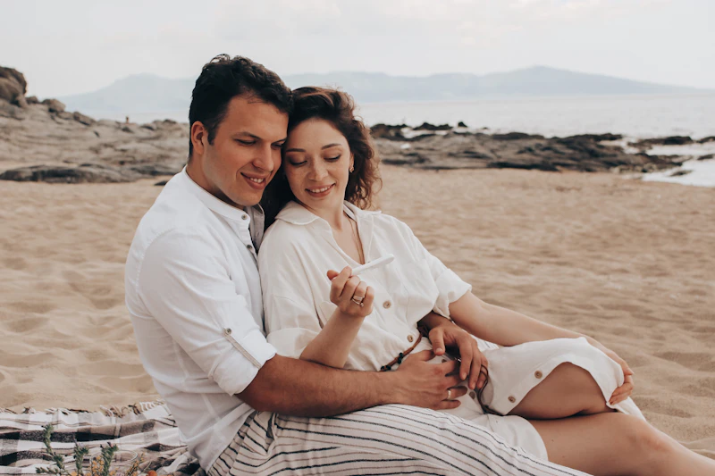 Casal gestante vivenciando momentos de afeto e relaxamento à beira-mar