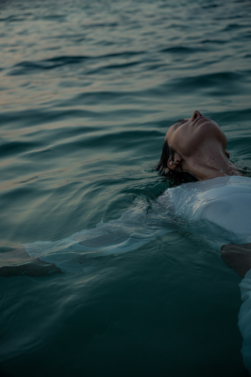 a woman floating on top of a body of water