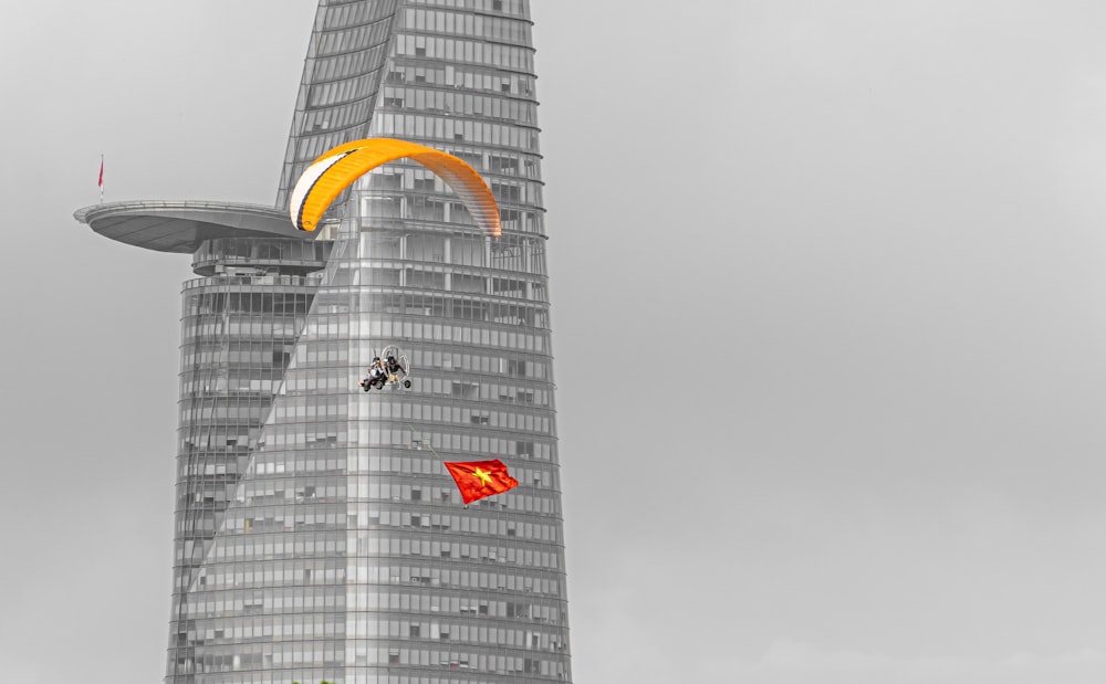 a person is parasailing in front of a tall building