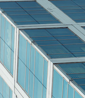 Modern glass storefront with sleek, reflective tempered glass panels under bright daylight.