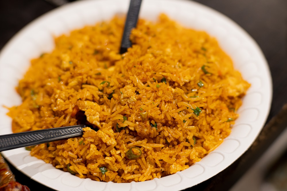 a white plate topped with rice and two black spoons