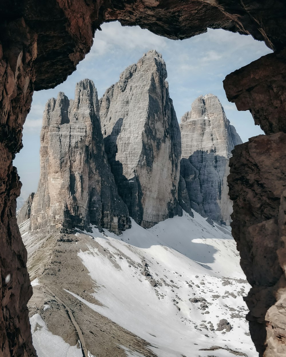 Blick auf eine Bergkette durch ein Loch in einem Felsen
