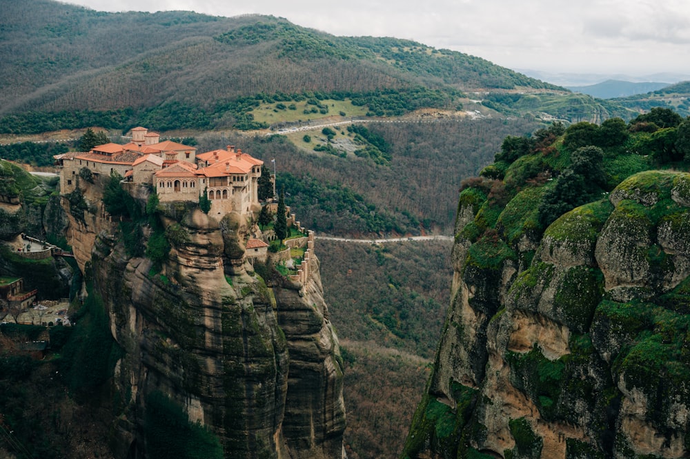 a castle perched on top of a cliff in the middle of a valley