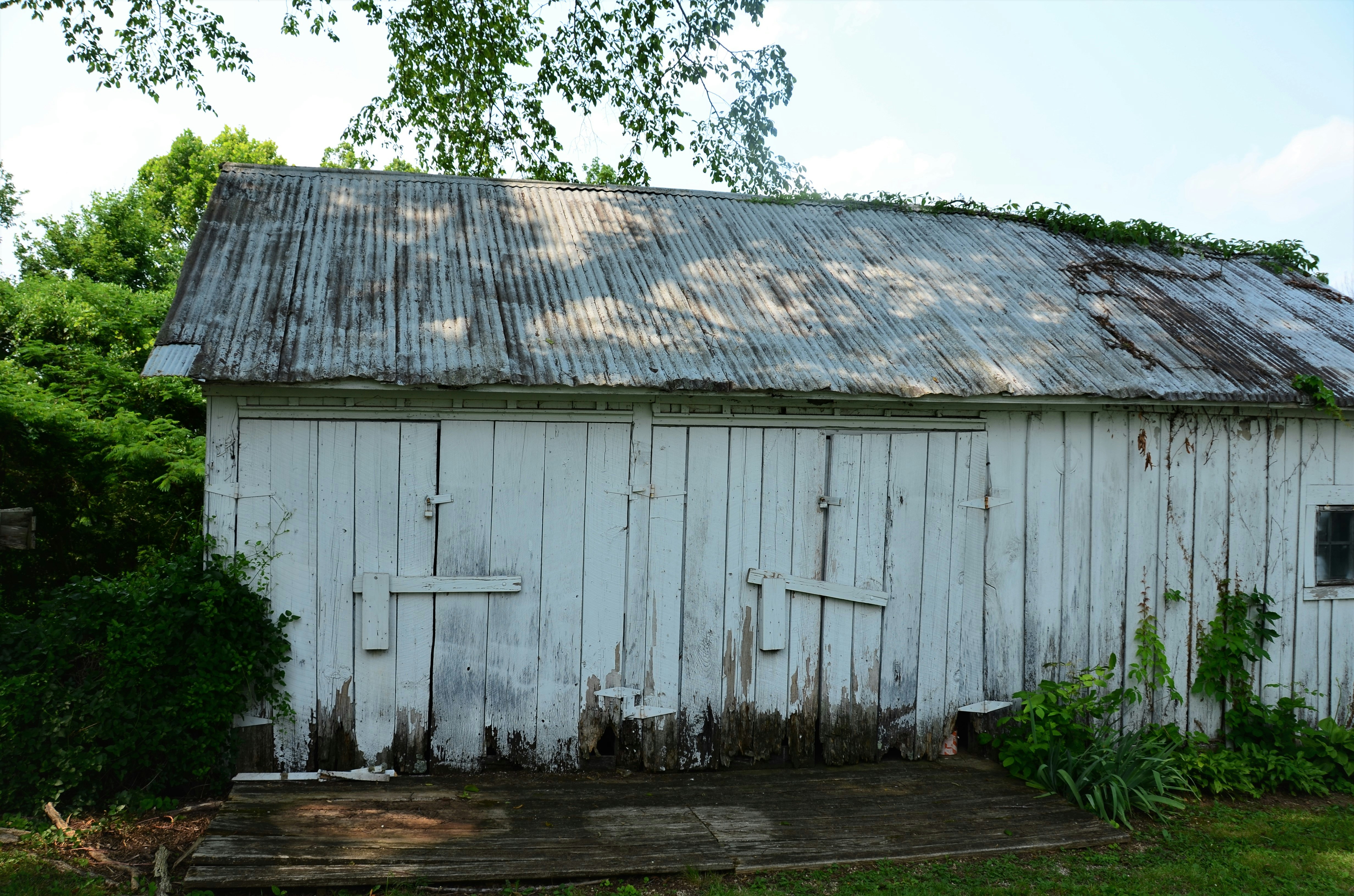 Wooden barn structure with weathered timber frame and corrugated metal roof in California countryside