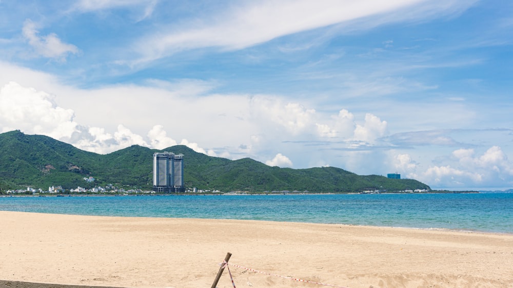 a sandy beach with a tall building in the background