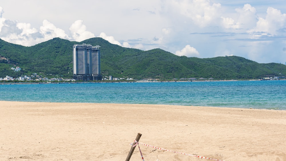 Una playa con un edificio alto al fondo