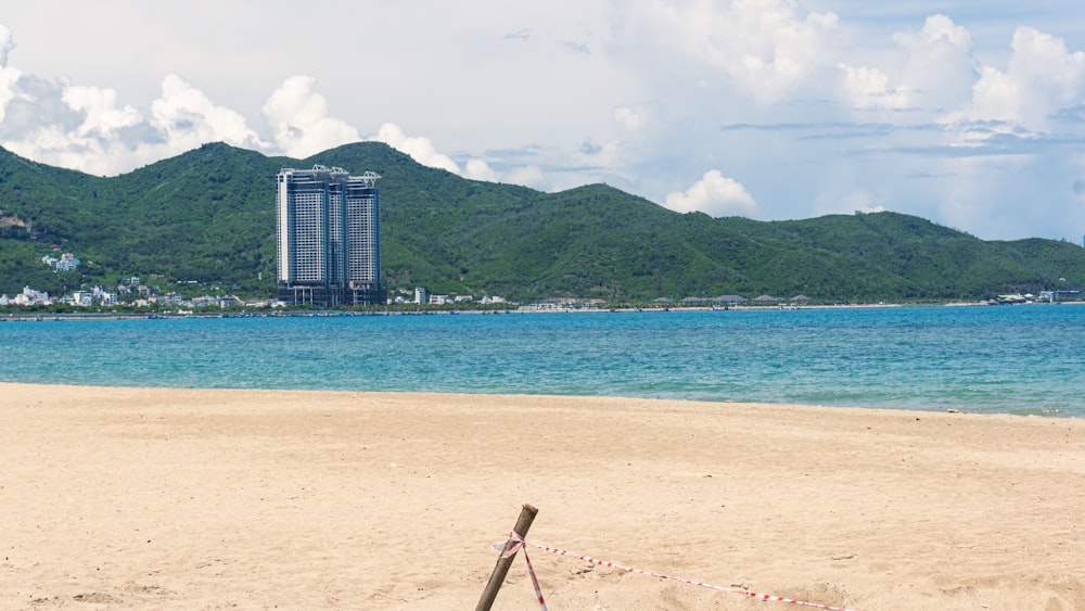 a beach with a tall building in the background