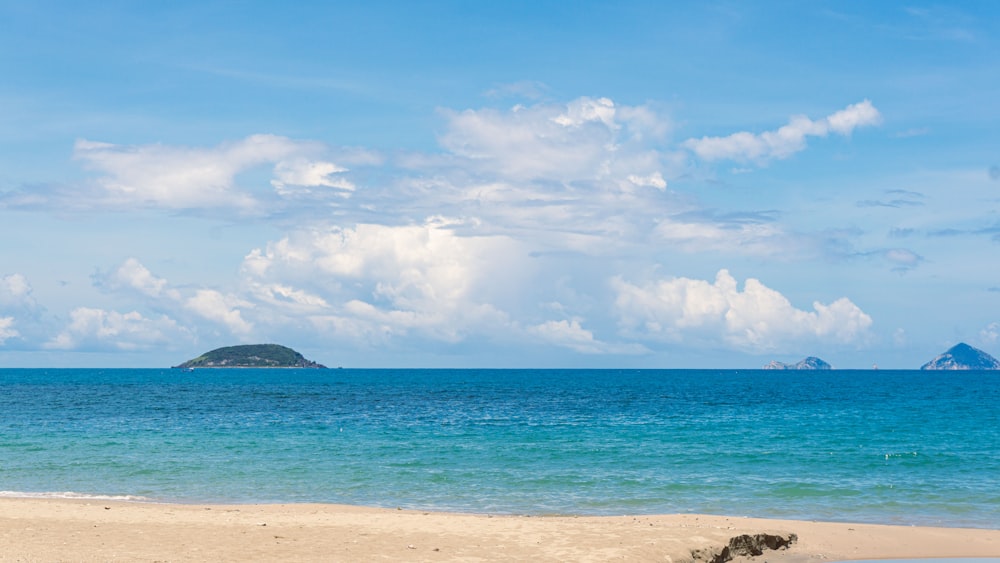 Una playa con una isla en la distancia