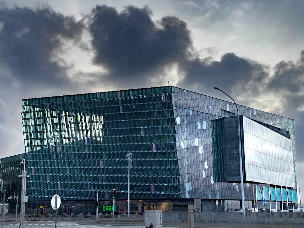 a large glass building sitting under a cloudy sky