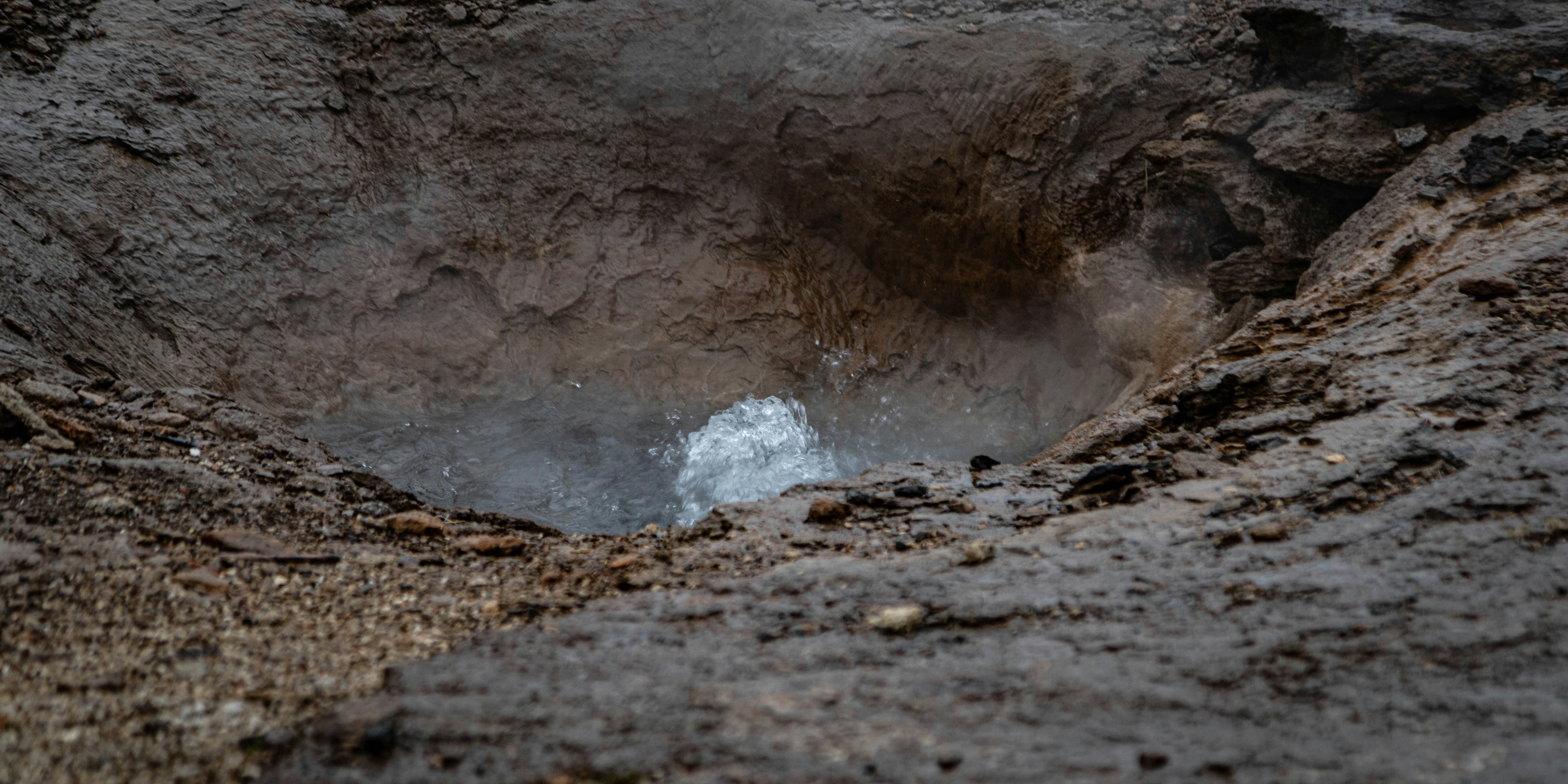 A hole in the ground with water coming out of it photo – Free Iceland ...