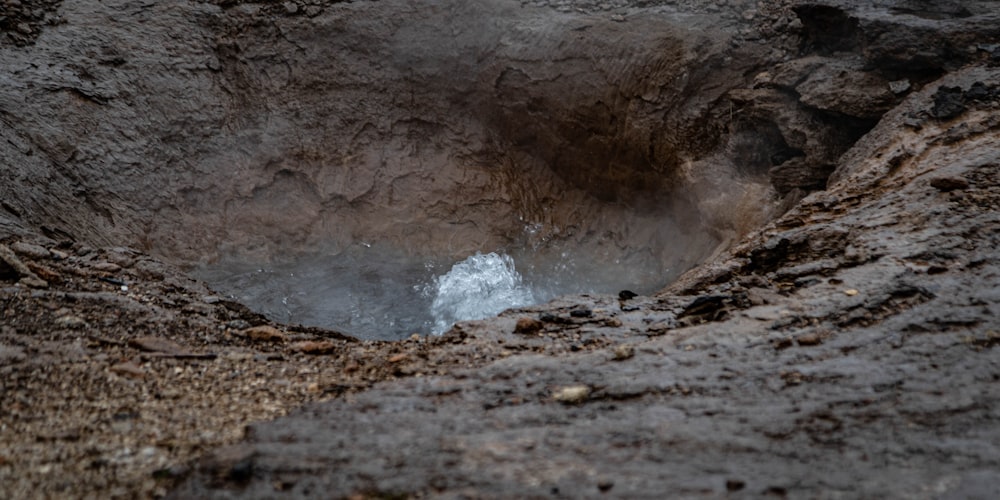 a hole in the ground with water coming out of it