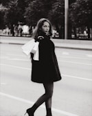 A stylish woman carrying a sleek black handbag from Ventriz on a city street.