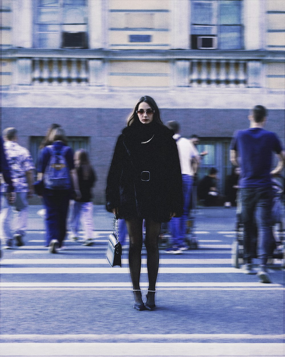 a woman in a black coat is walking down the street
