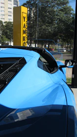 A sleek blue car parked in a modern urban setting, symbolizing rental services.