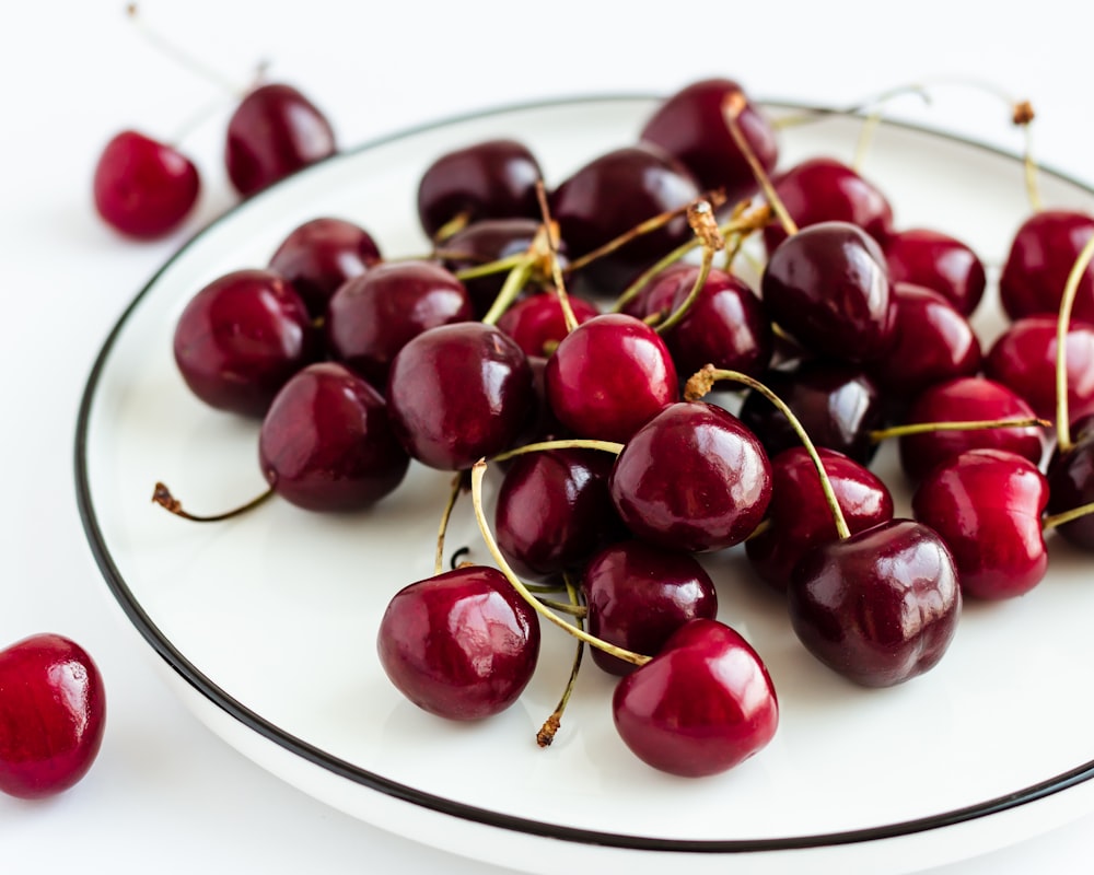 a white plate topped with lots of cherries