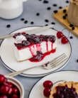 a slice of cheesecake with cherries on a plate
