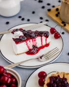 a slice of cheesecake with cherries on a plate