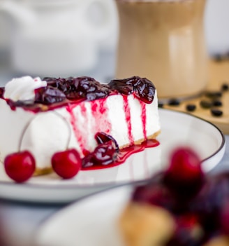 a slice of cheesecake with cherries on a plate