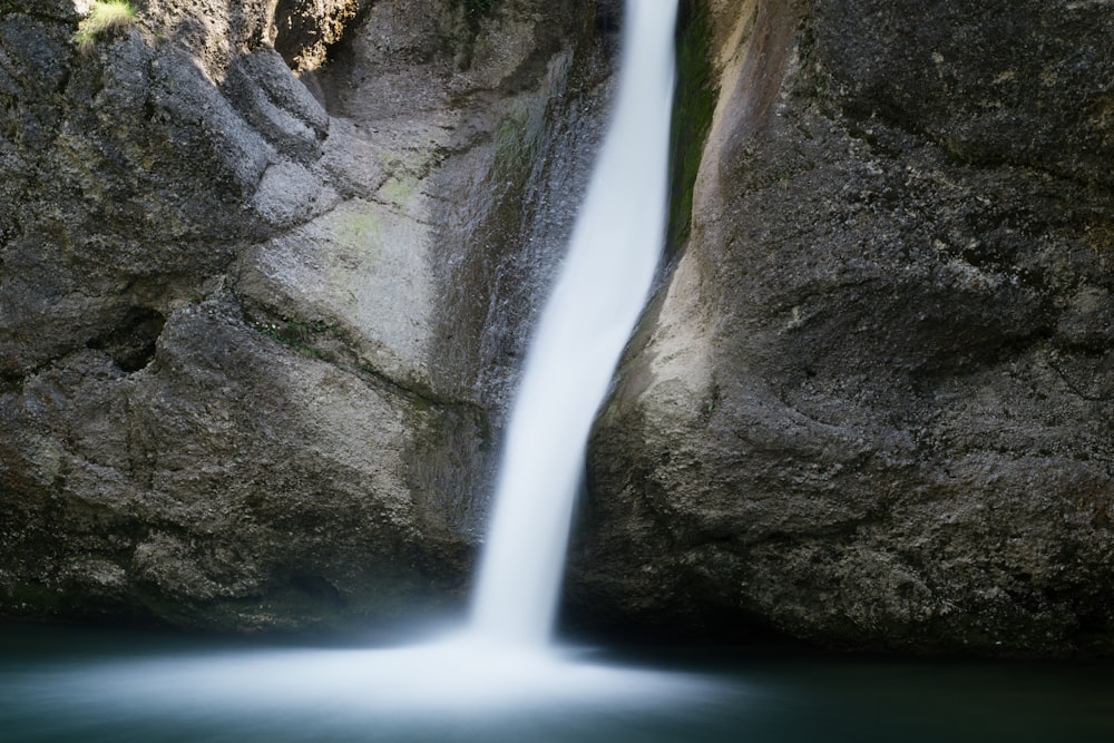 a waterfall is flowing into a body of water