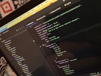 A computer screen displays a code editor with a dark theme. The code is related to a manifest file, showing JSON format data, including URLs, version numbers, and a description of an 'Xtreme Download Manager'. There are also multiple tabs open with filenames like 'background.html' and 'bg2.js'.