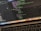 A close-up view of a laptop displaying code on the screen. The code editor is open on a dark-themed interface, showing lines of JavaScript with syntax highlighting. Below the screen, the keyboard of the laptop is partially visible. The laptop's dock at the bottom houses several application icons.
